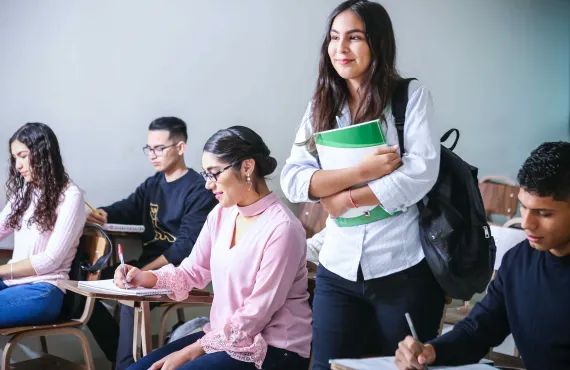 Student walking through classroom between other students
