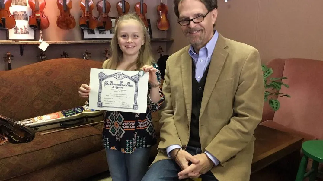 Abi Snell with her LSMD certificate Abi Snell in 2019 with her music teacher and her Level 3 Certificate