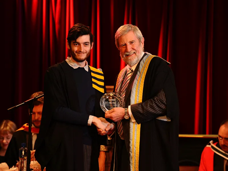 Student Graduating Diarmuid Hegarty Hands parchment to student
