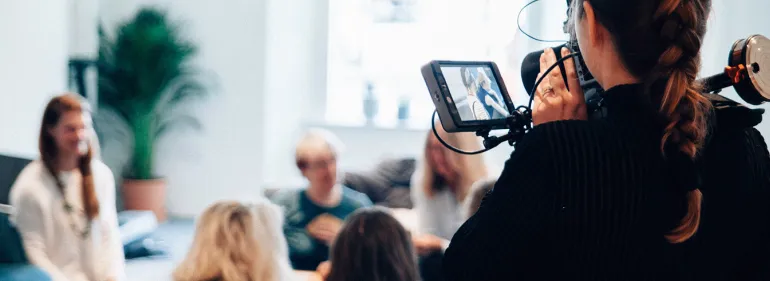 Image of a videographer filming in a corporate office space
