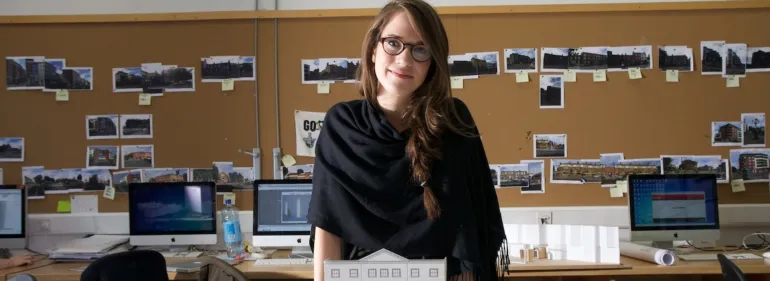 Visa requirements at Griffith College A female architecture student stands smiling behind a model of her work