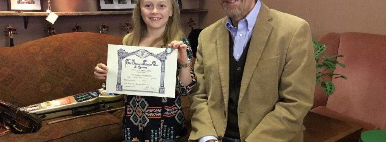 Abi Snell with her LSMD certificate Abi Snell in 2019 with her music teacher and her Level 3 Certificate