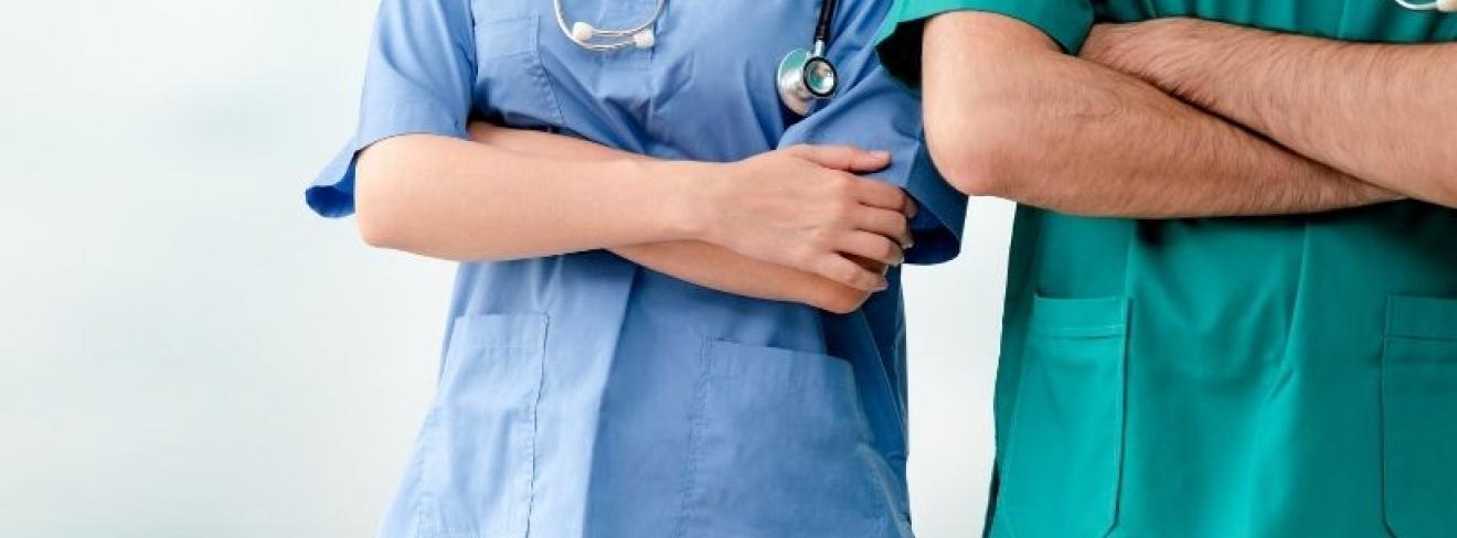 Two doctors, one in blue scrubs and one in green scrubs, standing with their arms crossed Apprenticeship student featured in the Irish Independent